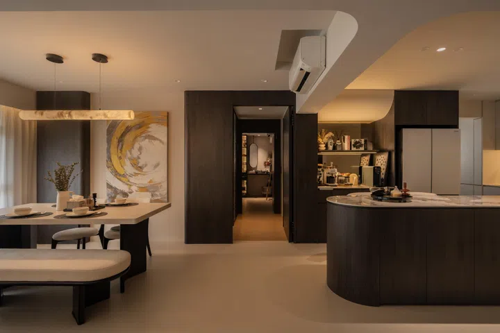 The kitchen island and dining area face the TV, supported by smart lighting and warm LED settings for movie nights.