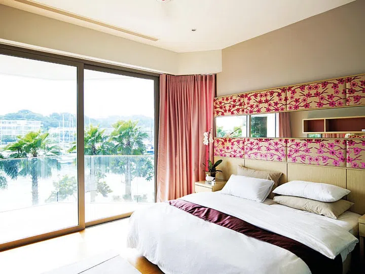 Master bedroom overlooks to Sentosa seascape in a 4-bedroom apartment in Oceanfront @ Sentosa Cove condominium with luxurious interior design.