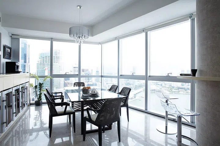 Decor is minimal in the dining area of this expat couple's 4-bedroom Marina Bay Residences condominium to draw attention to the view of Marina Bay and the Central Business District. Bread bowl, from Molecule. Dinner entertainment has included the National Day and Youth Olympics fireworks and the Formula 1 F1 night race.