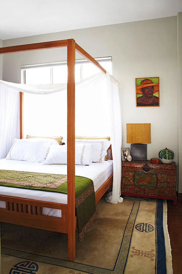 The Tibetan rug and chest blends harmoniously with the safari-themed decor in the master bedroom.