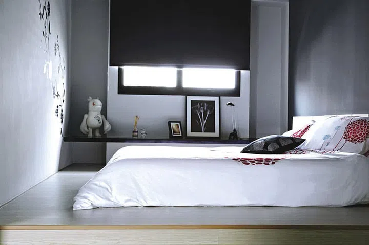 Graphic black decals bought in Malaysia embellish the master bedroom. above The entire master bedroom floor has been raised with a platform, with the bedhead fixed to the wall.