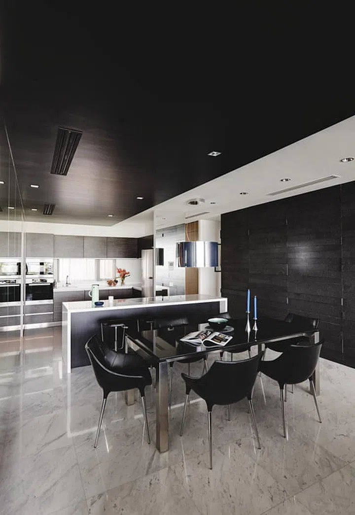 The dining table from Air is paired with chairs from Cassina in this dark modern 4-bedroom condominium in Sentosa Cove.