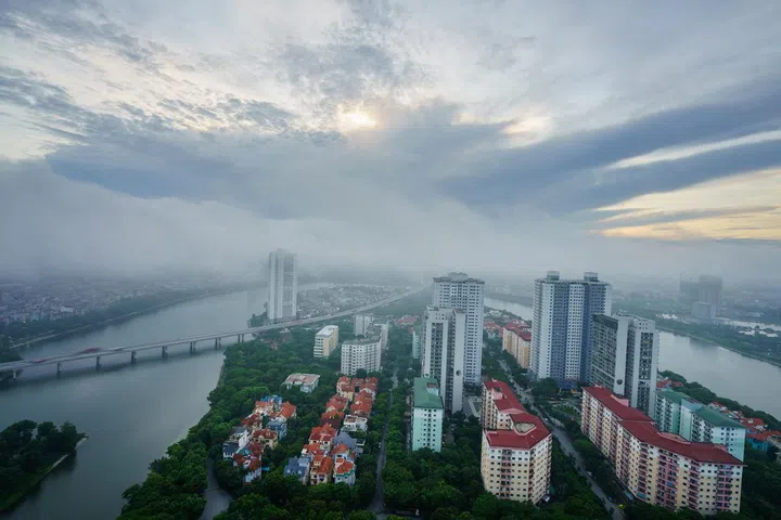 erial skyline view of Hanoi cityscape at dawn with low clouds. Linh Dam peninsula, Hoang Mai district.