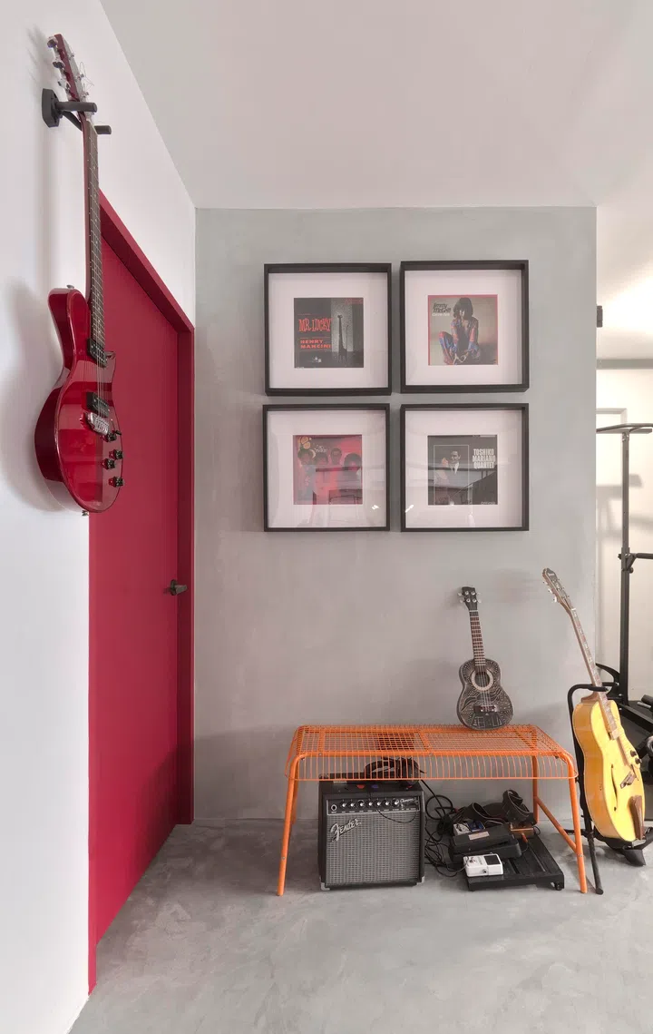 A bright orange bench, which Grace sourced, couples well with the red accents and grey tones around Mike’s music corner.