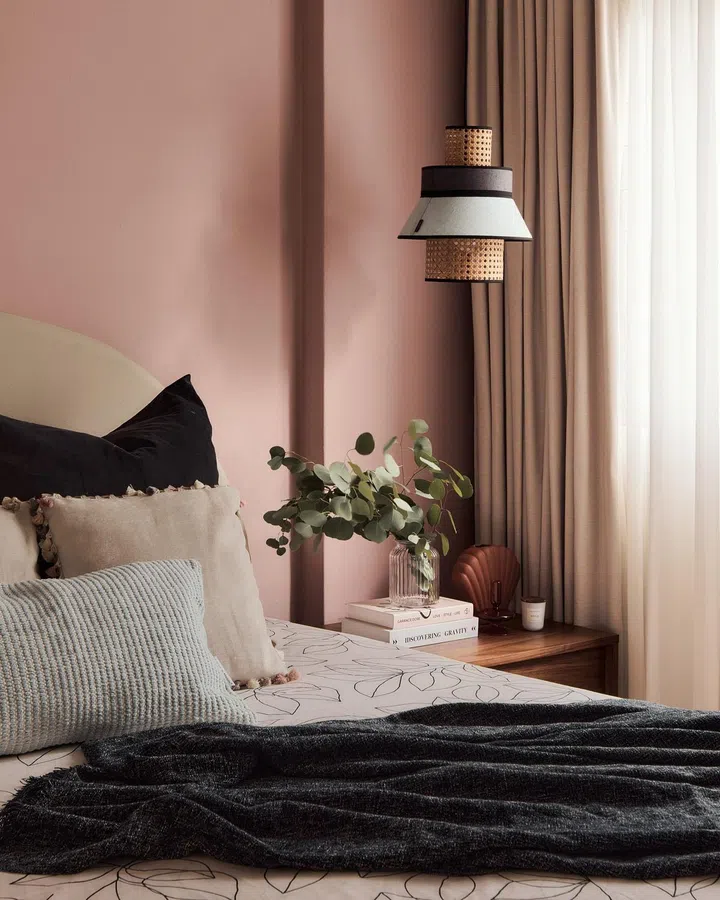 Close up look of the pink master bedroom punctuated with black accents and rattan for a chic, laid-back feel in this Clydeswood condominium apartment.