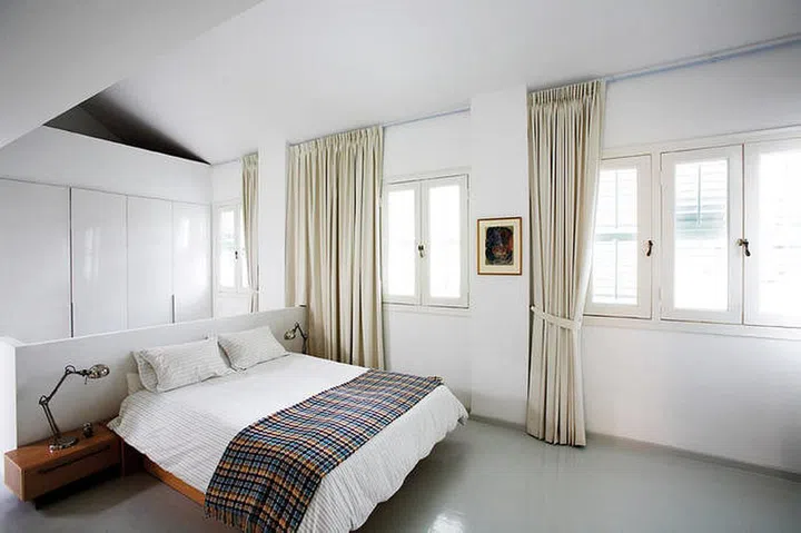 A high ceiling, plenty of natural light and the absence of solid walls and full-height partitions make the master bedroom feel extra spacious. Missoni throw from Miles & Theodore. (Reno: $250K excluding furniture)