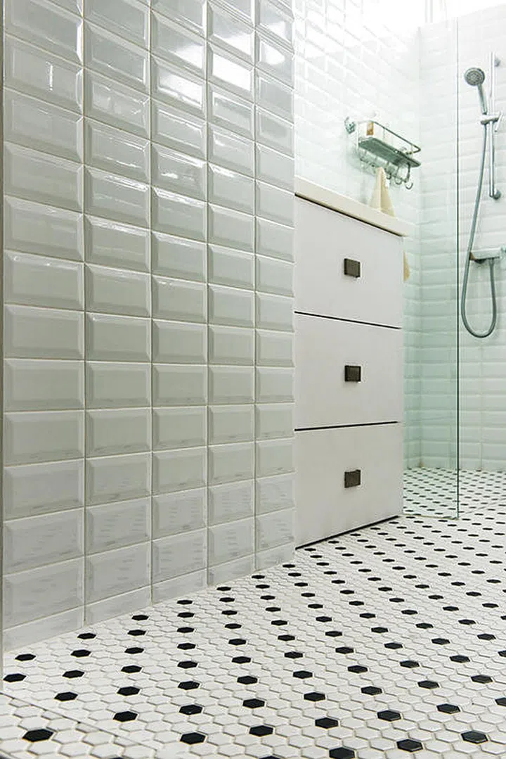 The "subway" style wall tiles are a visually interesting contrast to the dainty honeycomb form of the floor tiles. (Total Renovation costs: $140,000)