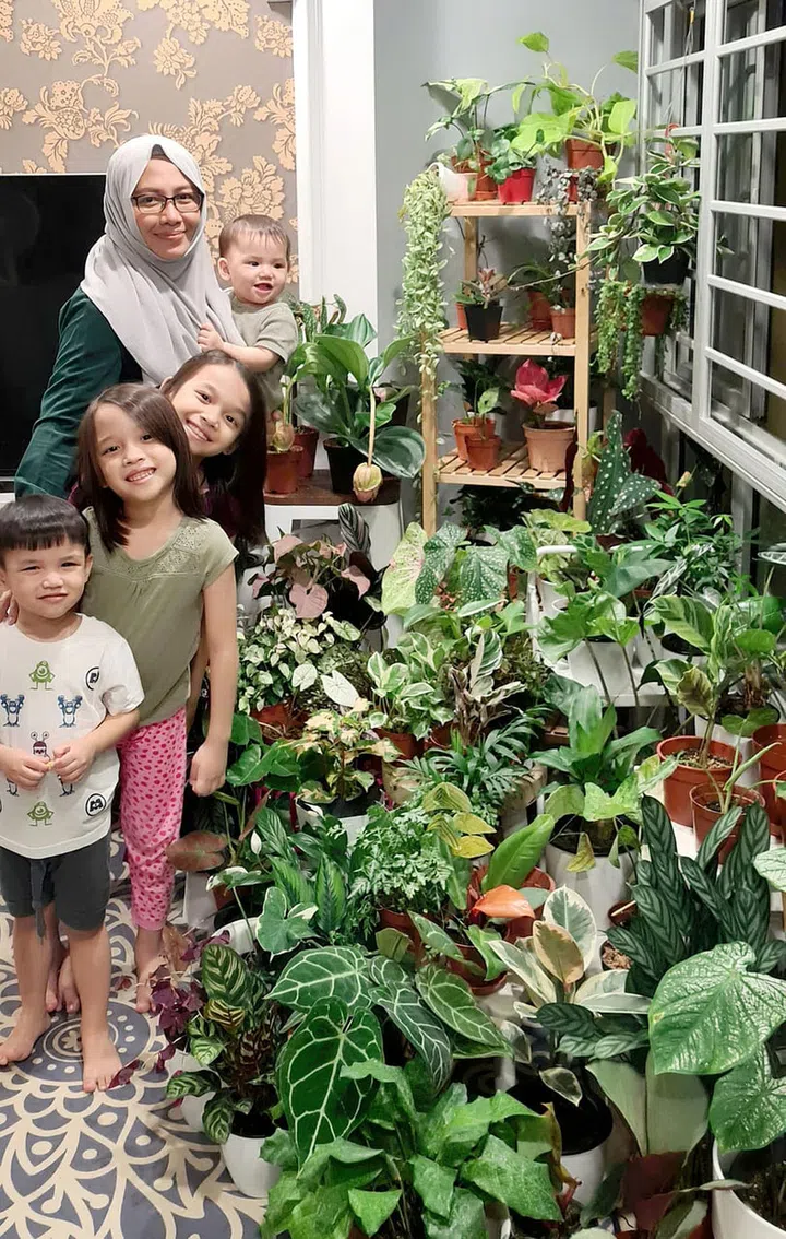 Ms Nurul Atirah and her children in the corner of her living room dedicated to her plant collection. PHOTO: COURTESY OF NURUL ATIRAH  embed via Straits Times