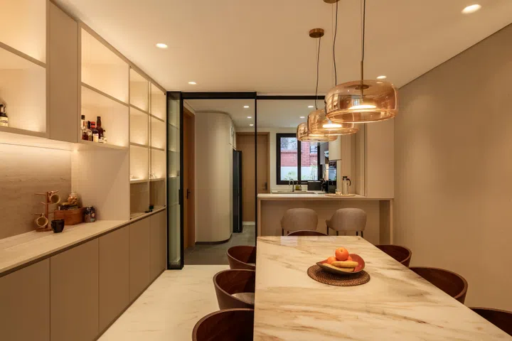 A breakfast counter and concealed glass partition improve connectivity between the kitchen and dining area, allowing conversation to continue while cooking.