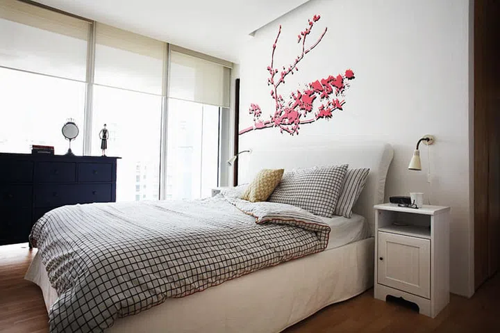 The homeowner shows her feminine side in her bedroom furniture and the wall decal.