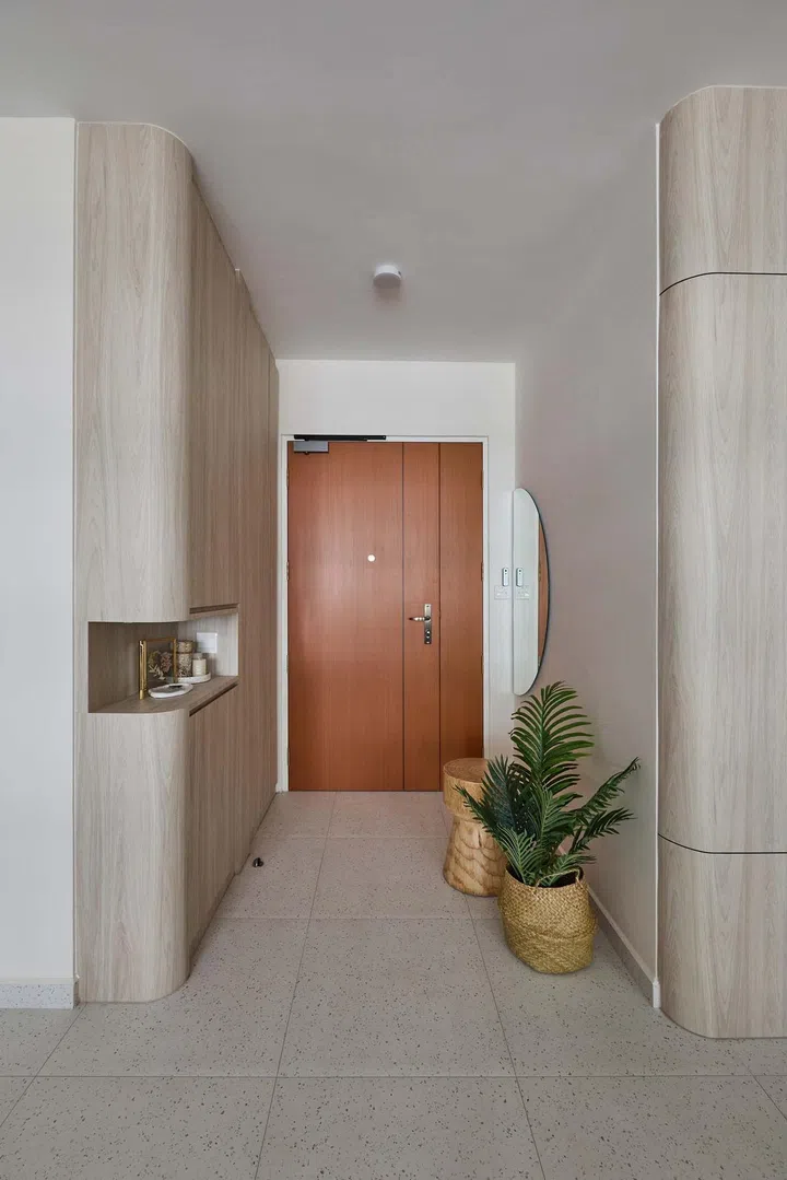 Curved cabinets along the entryway in a minimalist 5-room HDB BTO in Tampines.