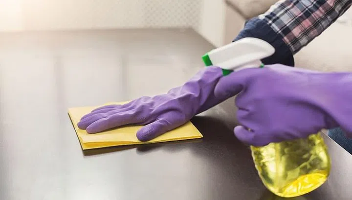 Woman using spray cleaner on wooden surface. Unrecognizable girl polishing furniture, housework and chores concept, copy space