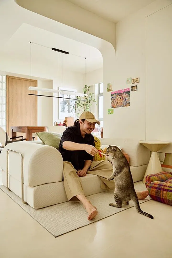Kai relaxes in the open-plan living area with his cat Monmon.