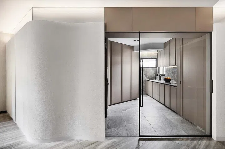 hallway outside kitchen with minimalist glass door divider and curved wall