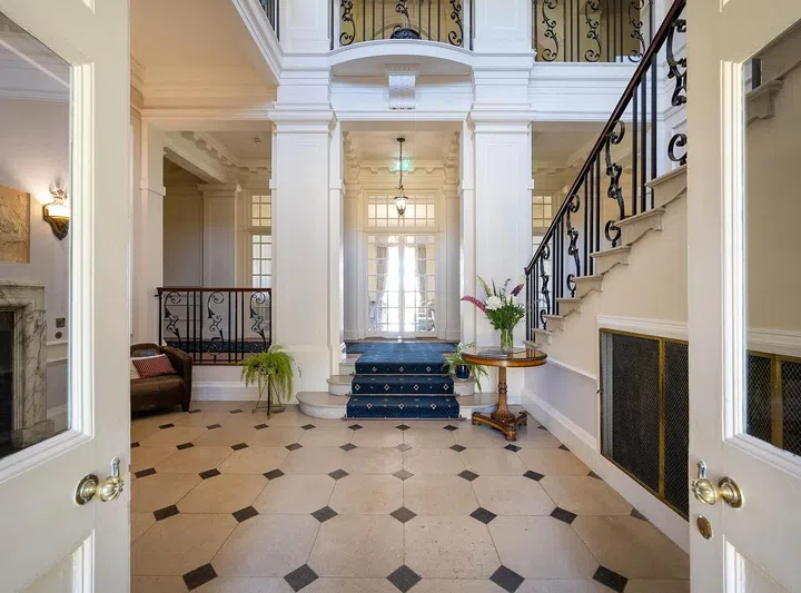 The stunning entry hall features a wrought iron staircase.