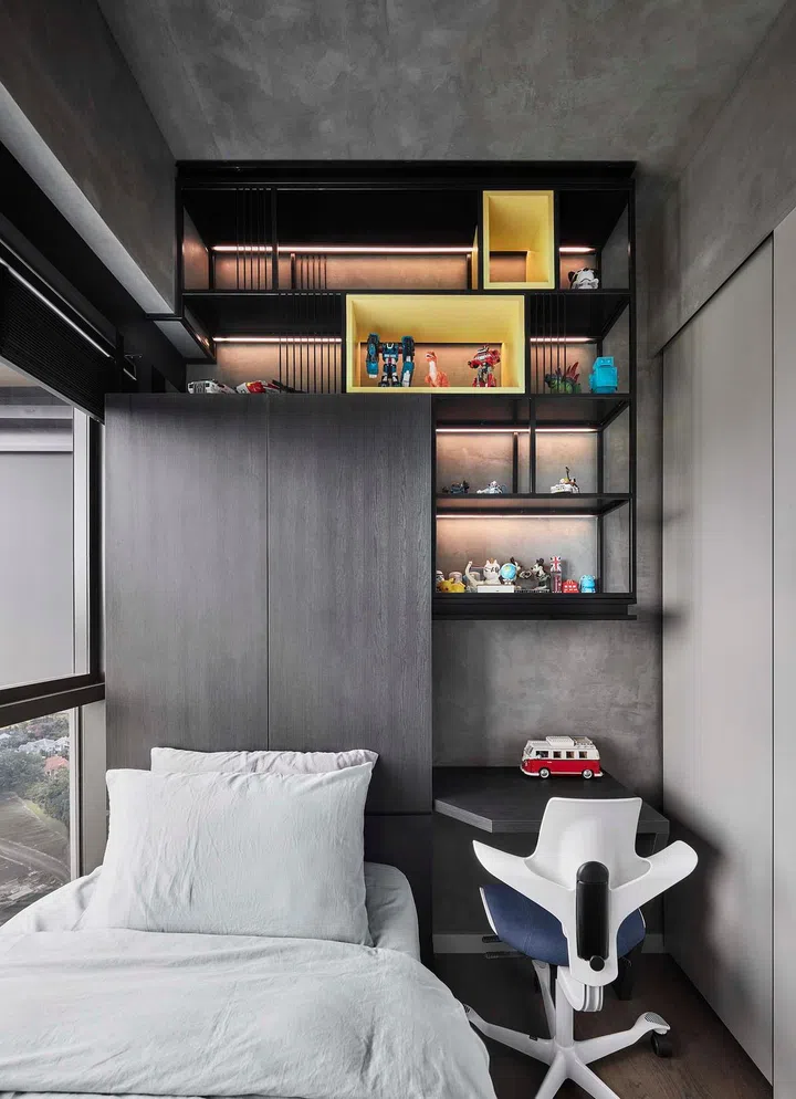Steel open shelves hang over the study table and bed in the son's bedroom in this 1,184 sq ft 4-bedroom condo in Queenstown.