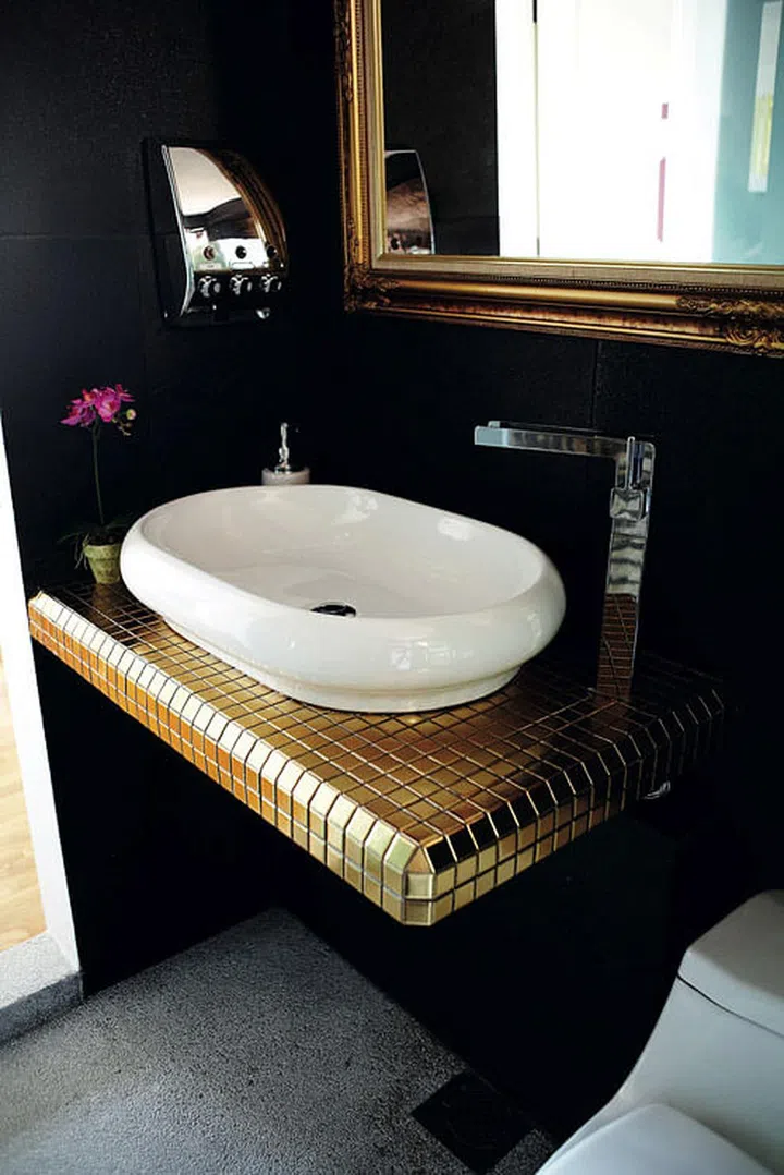 The black tiles make a good backdrop for the gold-mirrored frame and mosaic tiles.
