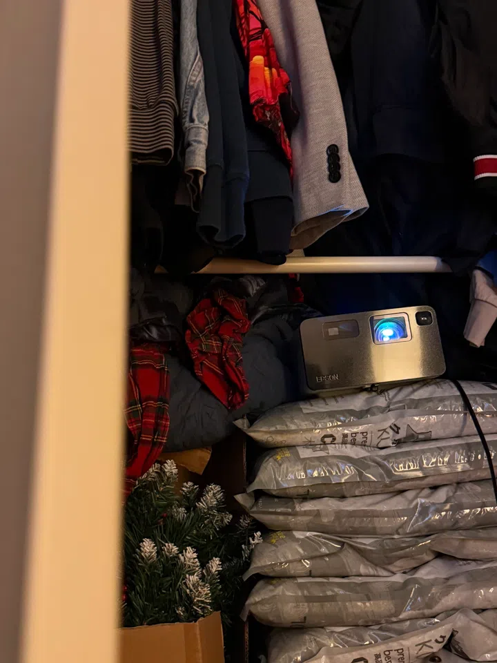 Not us hiding our projector in the Christmas closet to keep it out of the feline’s reach.