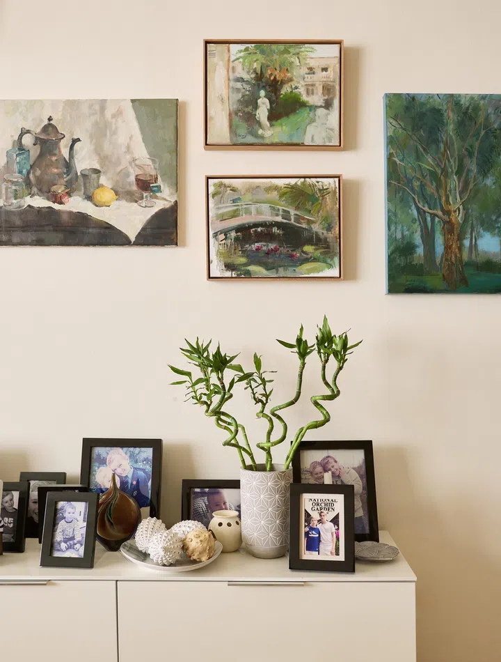 A curated display shelf with artwork and framed family photos, capturing memories and place.

