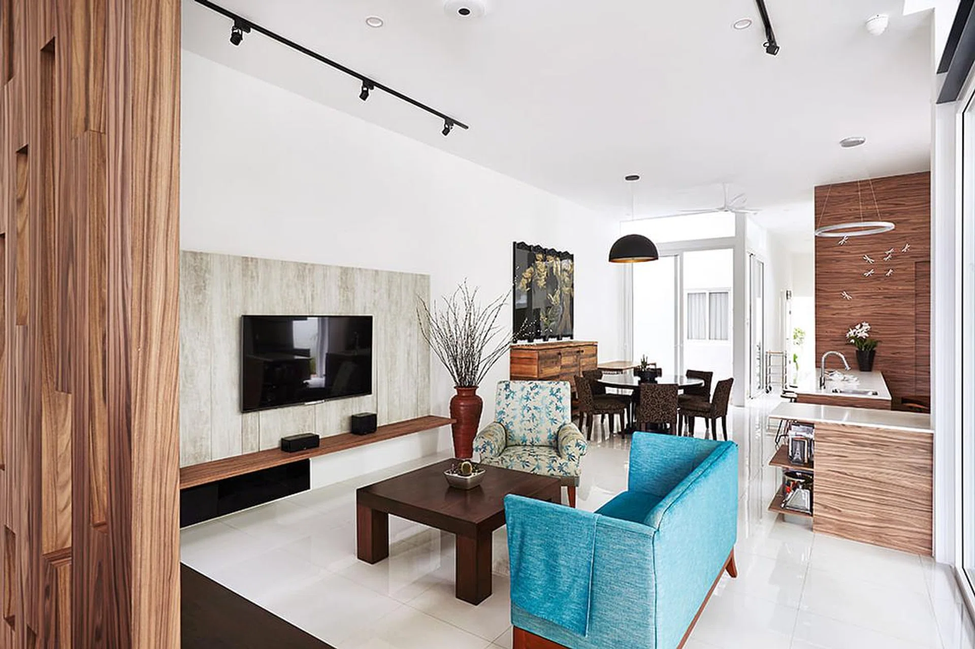 [Renovation Costs: Over $1.6 million] Pops of colour from the furniture stand out against the living room’s neutral colour scheme.