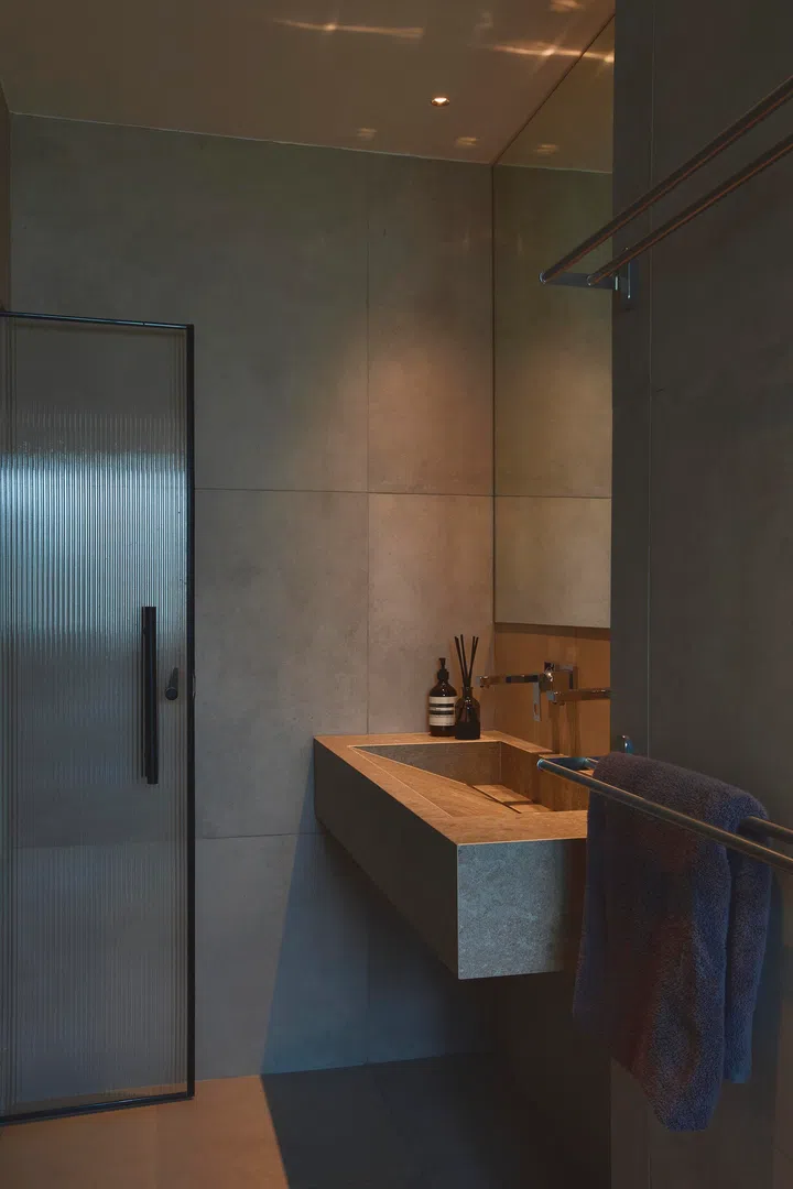 The primary en suite is also done in the Brutalist style, but certain earthy elements feel Japanese-esque. 
