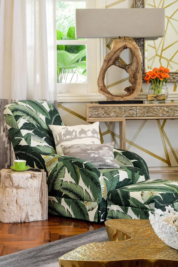 Bold tropical print, sculptural table lamp, parquet flooring and organic-shaped coffee table are part of the same theme: nature.
