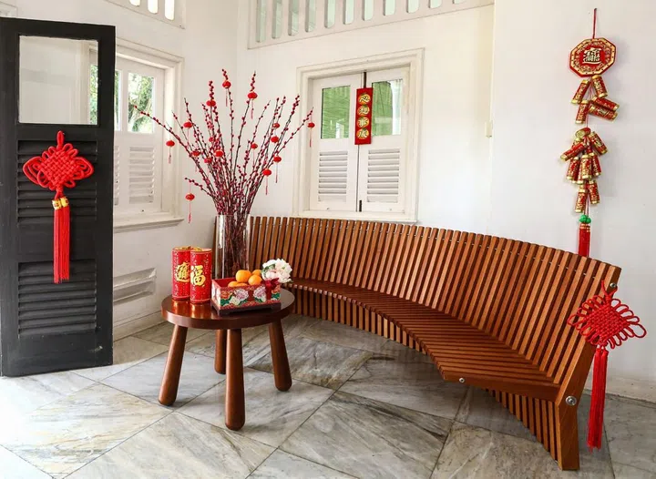 On a side table, 1B2G Fine Vintage Furniture store owner, Lynette, has placed pussy willows, a box of oranges and firecracker decorations on it.