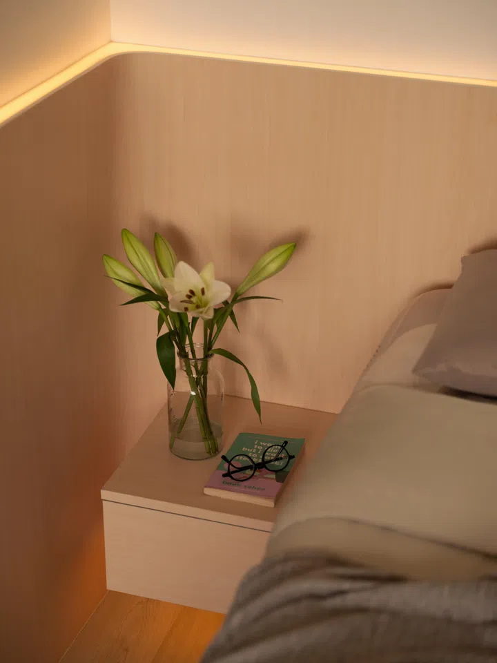 Concealed lighting above the headboard introduces warmth without adding visual clutter, maintaining the home’s restrained material palette.