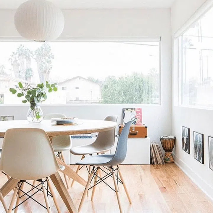 Light wood round dining table and white and grey chairs