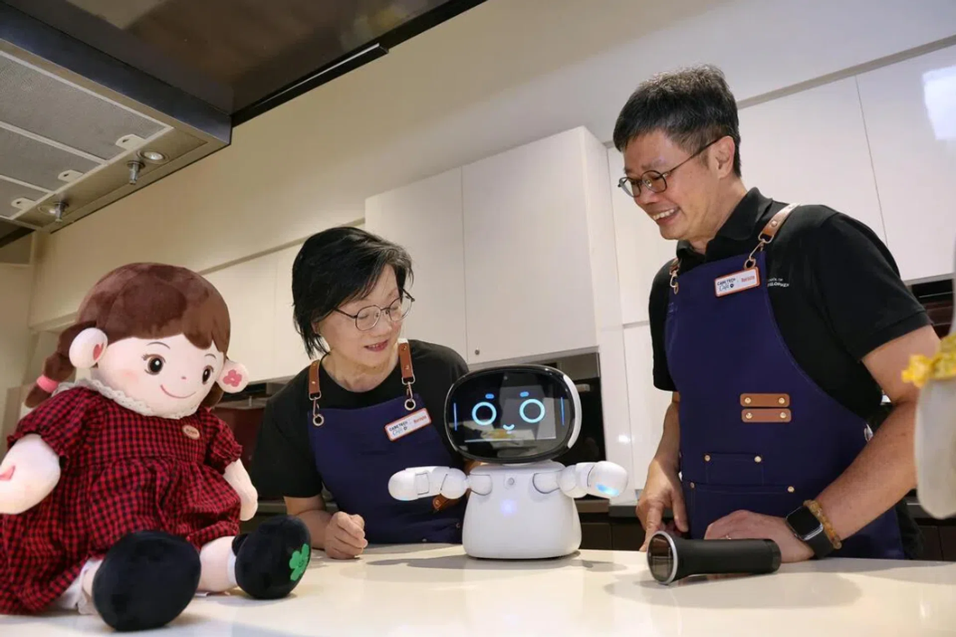 SUSS associate professor Kelvin Tan (right) explaining the features of a robot to Kampong Chai Chee resident Emily Choo at the Care Tech Cafe at Heartbeat@Bedok on July 31, 2026.