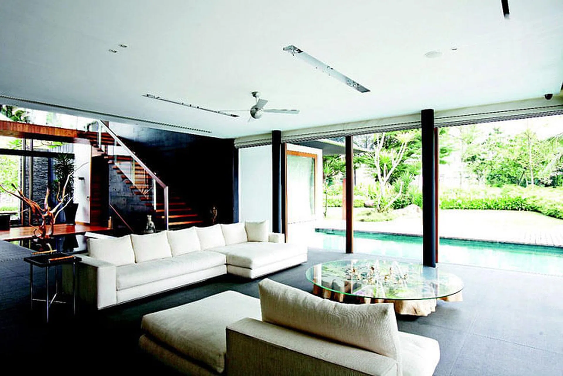 The living room enjoys a “borrowed” view of the Sentosa Cove seascape beyond the boundaries of this 2-storey bungalow in Sentosa Cove. Designed by architect Greg Shand and interior designer Angie Chan of Index Design.