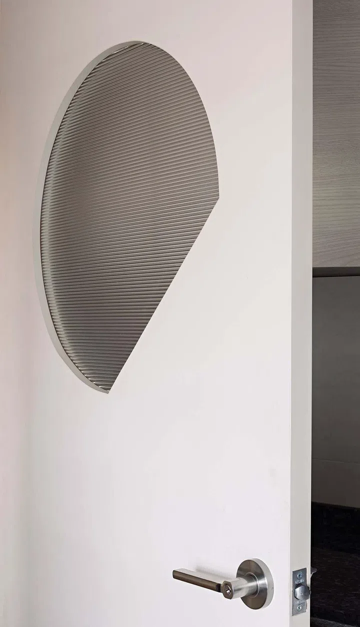 A fluted glass panel allows light from the kitchen into the living space. Its unconventional geometry was inspired by a Chinese poem about the moon rising over the mountain.