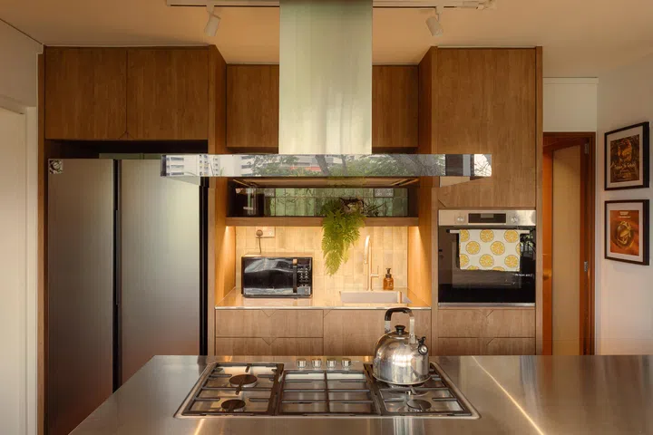 The reoriented kitchen as a welcoming threshold, with its island stove designed for cooking, hosting, and even photoshoots.