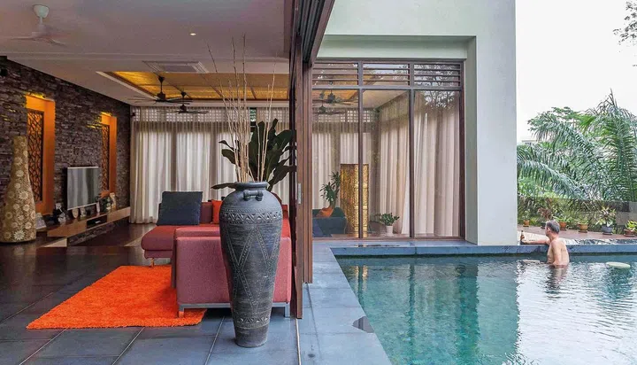 Full length glass windows are used to allow the interiors to merge fluidly with the lush greenery outside.