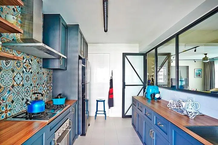 Vibrant Peranakan tiles and blue-hued shaker-style cabinetry come together in this bright and airy kitchen. Design: Fuse Concept