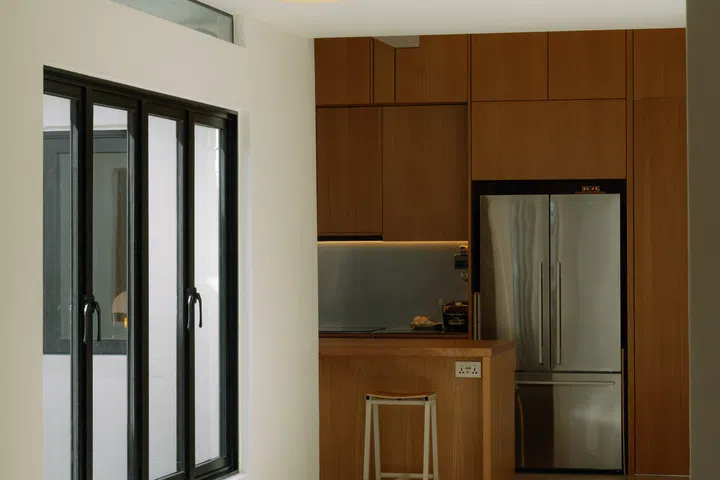 The kitchen sits immediately beside the entrance, making it the first space to welcome them home.