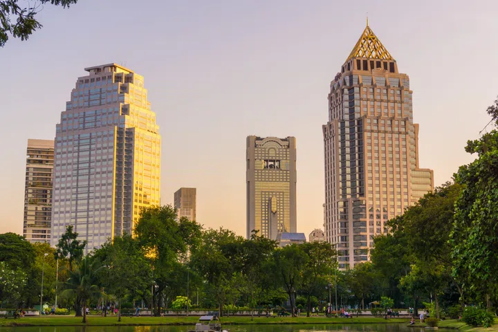 Lumpini park business district Bangkok cityscape from park with sunset sky Thailand.