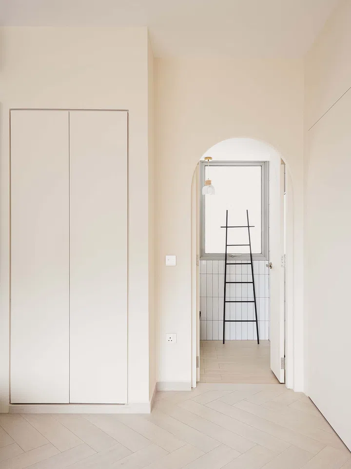 The same arched door swung open, revealing how the playful design element serves both function and form within the stylish interior.