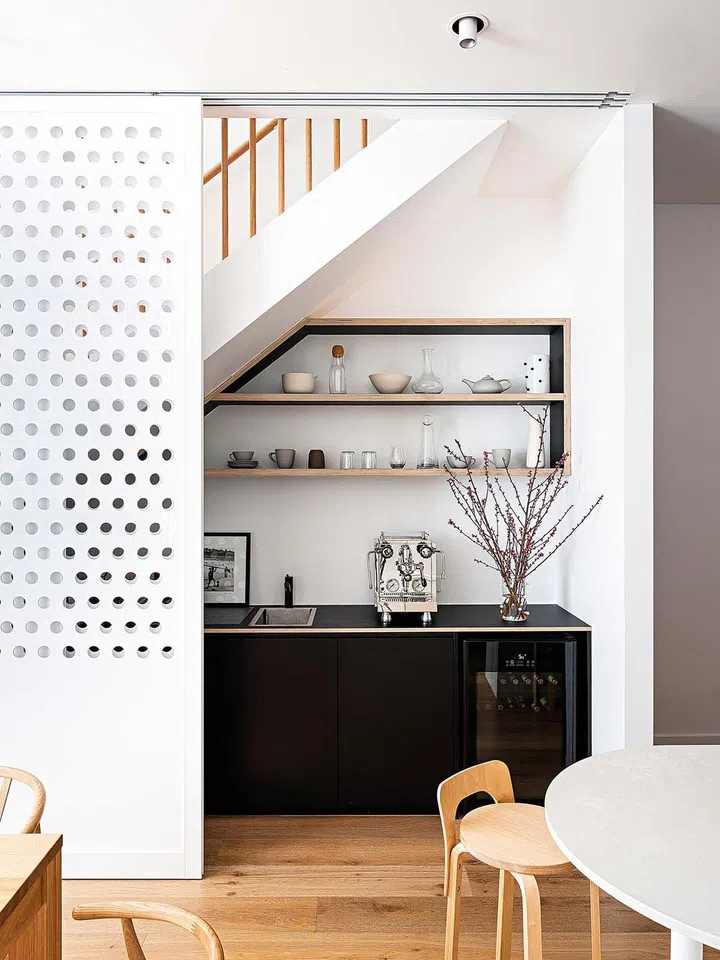 A coffee and bar area below the stairs can be screened off with custom sliding doors.