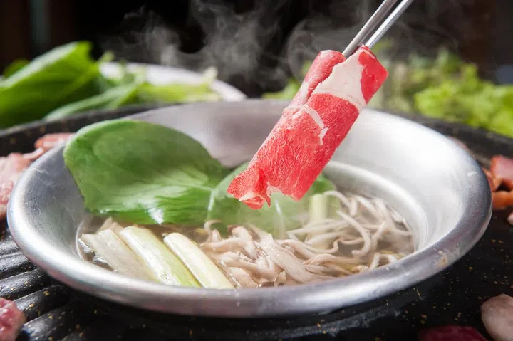dipping beef in Shabu-shabu hot pot steamboat. Photo 123RF