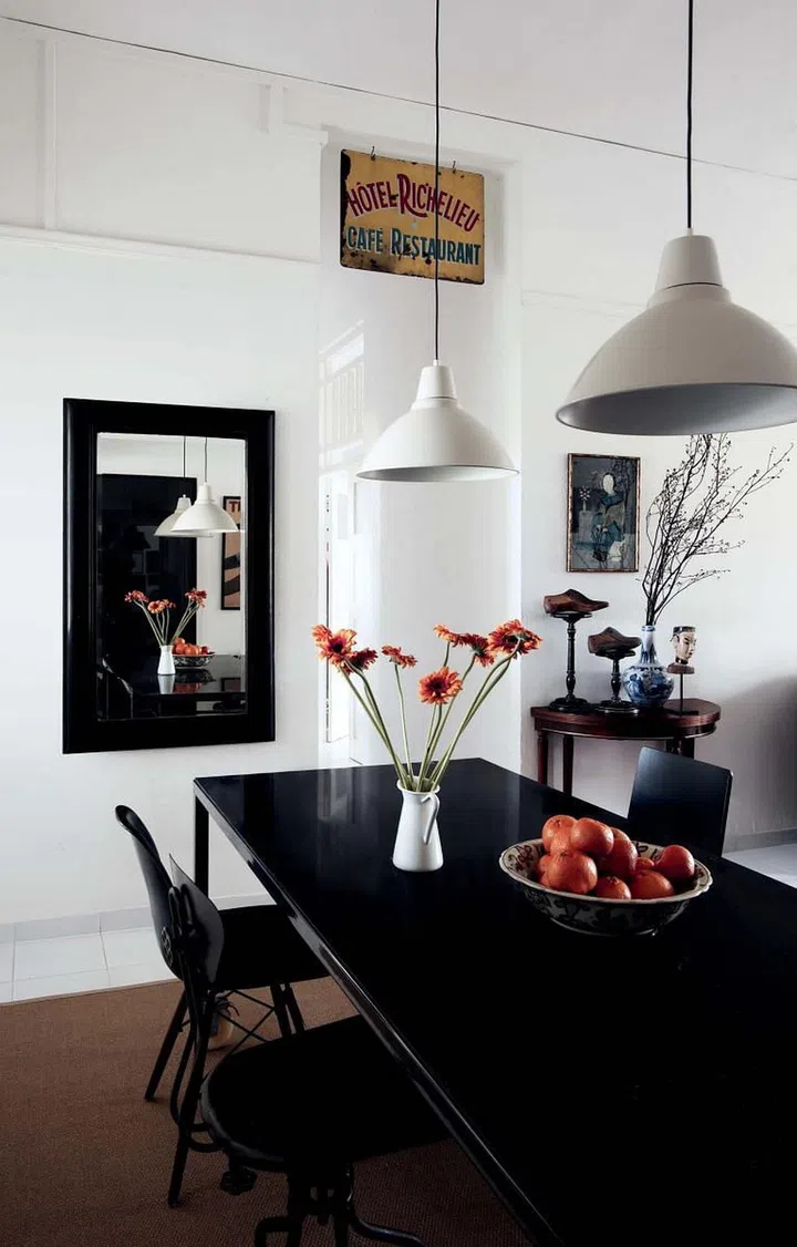 The high ceiling and regular rectangular layout appealed to the homeowner as it was easy to visualise how the space could be decorated. The “gas station” enamel lampshades complement the look of the dining table and chairs.