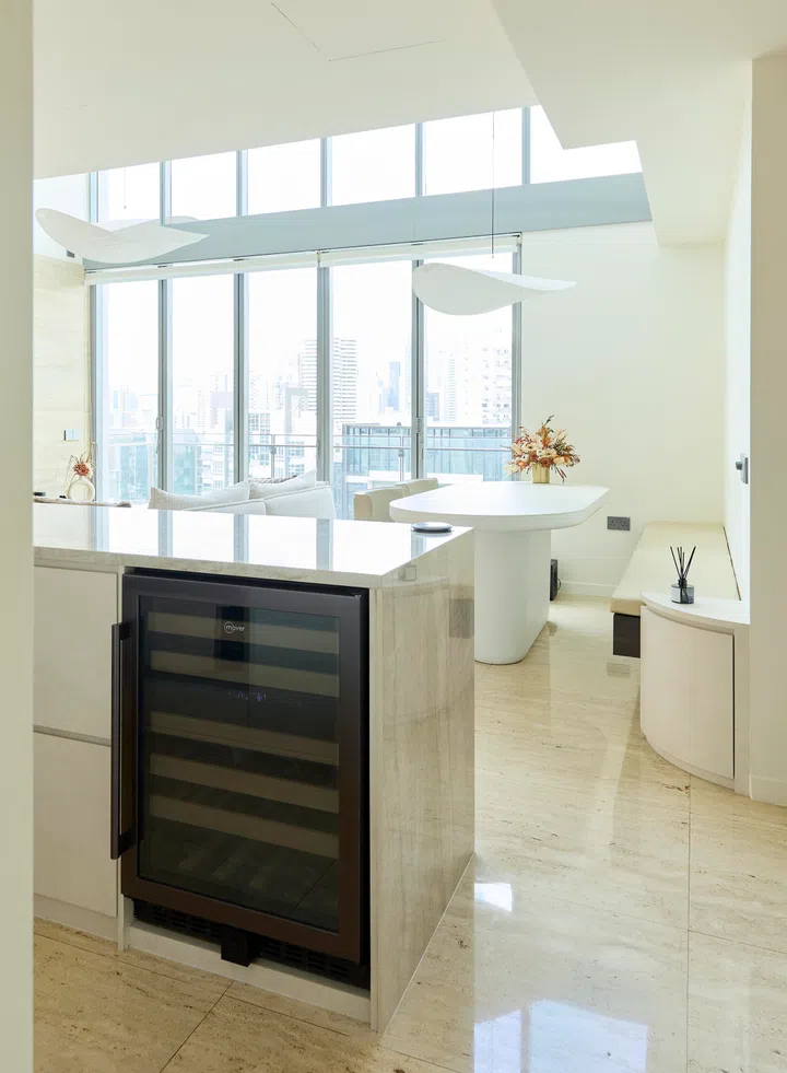 Warm tones and travertine textures meet in this refined kitchen corner, where every surface doubles as stylish storage.