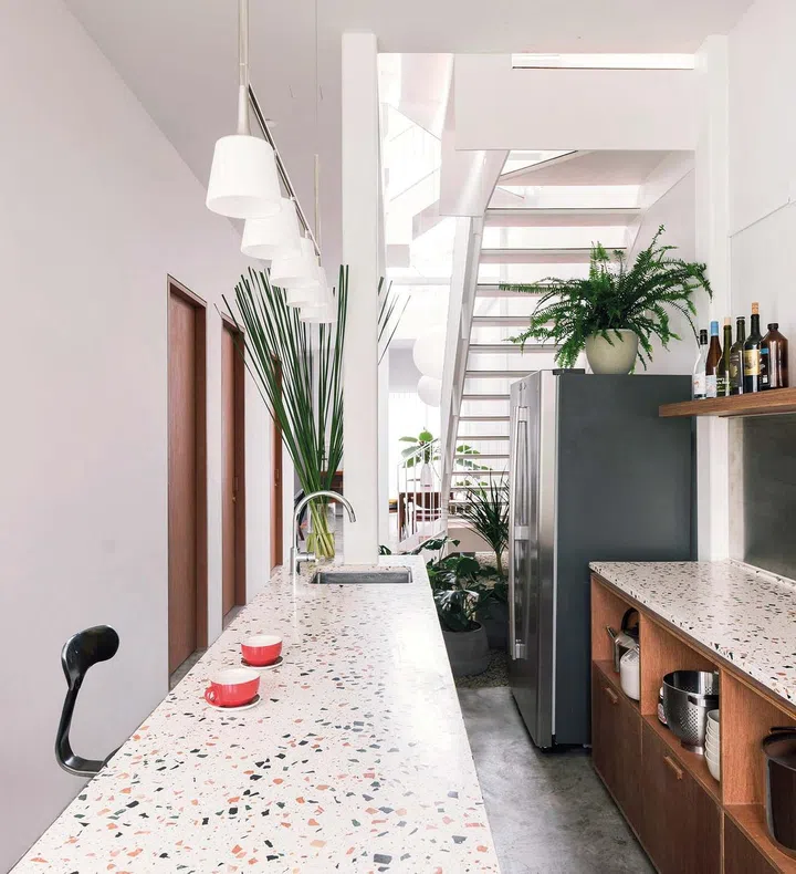 The design of the open- concept kitchen is derived from its utilitarian nature without being mundane. As with the rest of the home, it enjoys plenty of daylight and cross-ventilation from the OPPOSITE Light from the atrium fills the home and makes the spaces bright, airy and welcoming. atrium and rear windows, along with views of greenery from the rear garden and indoor courtyard.