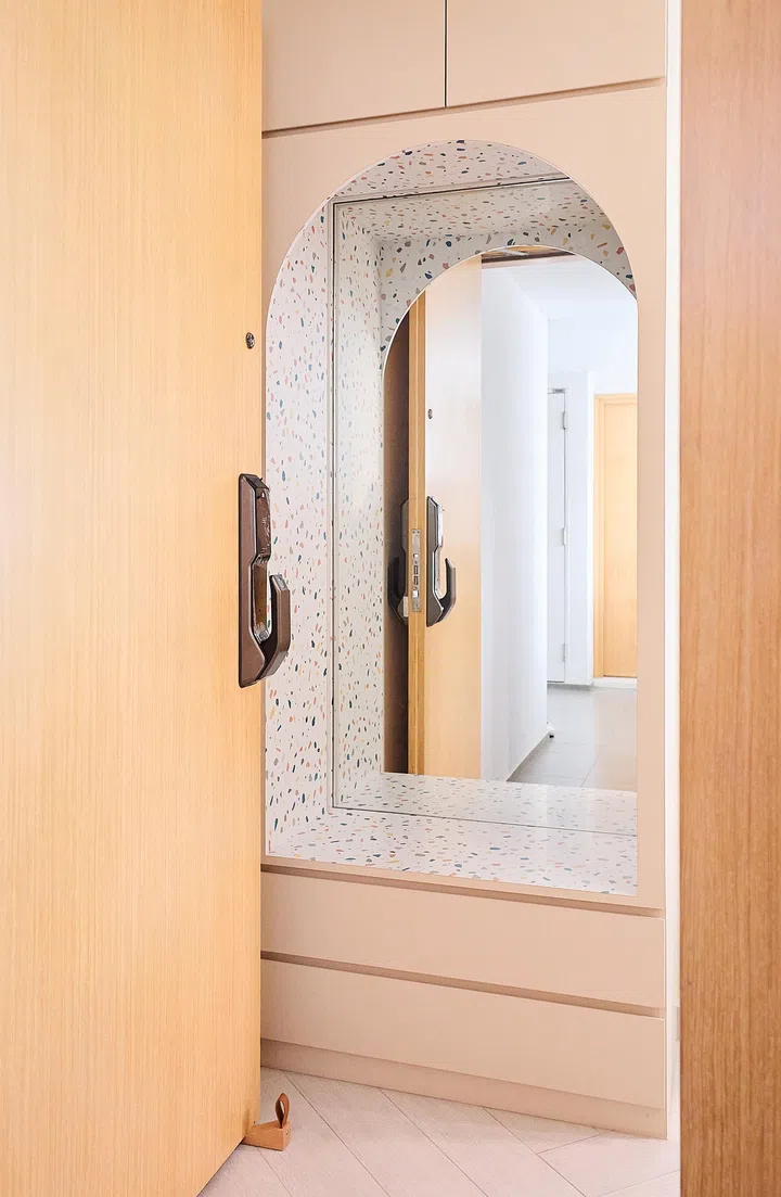 Vibrant and welcoming foyer showcasing a colourful terrazzo-clad niche with a built-in bench and mirror, setting a playful tone right at the entrance.