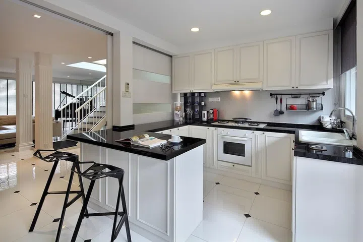 Keeping to the monochromatic color palette of black and white, the double storey terrace house adopts a traditional English look with a modern rustic edge, yet not too raw to loses its elegance. To soften the color tone, the living room uses a large landscape mirrors with finishes of wood trimming to create an instant classic English look. Besides, the use of floor-to-ceiling mirror panes dramatize the already spacious layout. A custom-made TV Console in whitewashed wood grain laminate complements the lofty feel of the living space. The double columns link up the flow of white tone throughout the house with the use of distinctively dark walnut stairway, while the decoration metal pillar design on the second level elevates the height of the tall ceiling and the rustic pendent light, creating a English lofty feel.