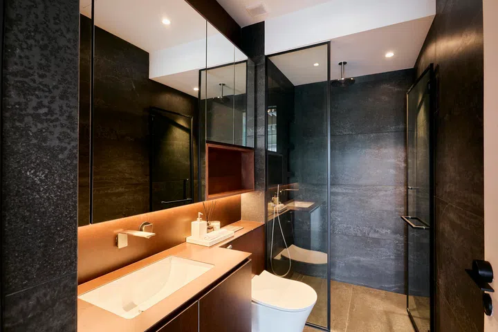 Glass partitions and mirrored surfaces keep the space visually open while maintaining clear zoning.