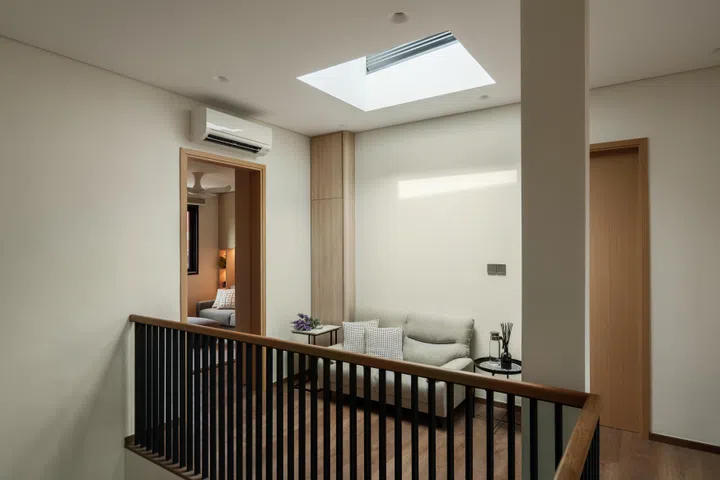 A skylight above the upper landing brings daylight deep into the home while turning a circulation space into a quiet architectural pause.