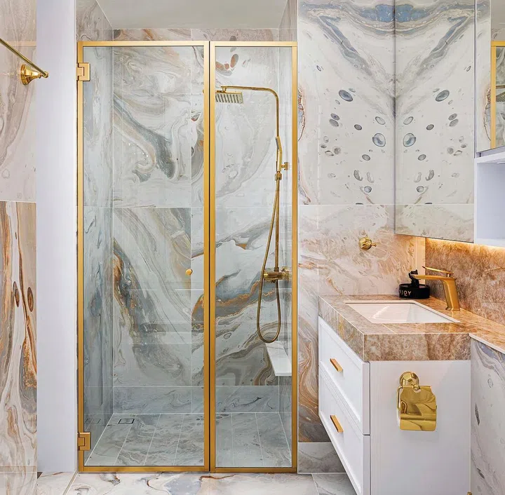 The varying grains of the marble-like tiles add some visual drama and textural variety to the bathroom.