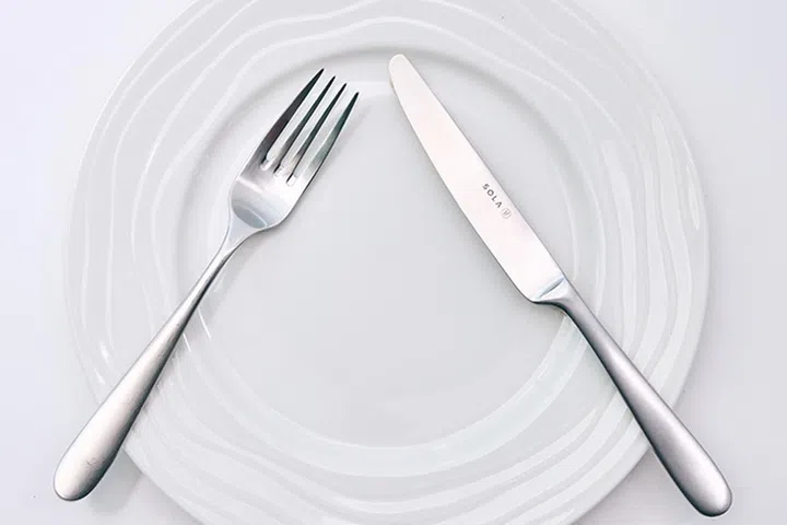 Fork and knife in a "V" shape signals a pause to the waiters.