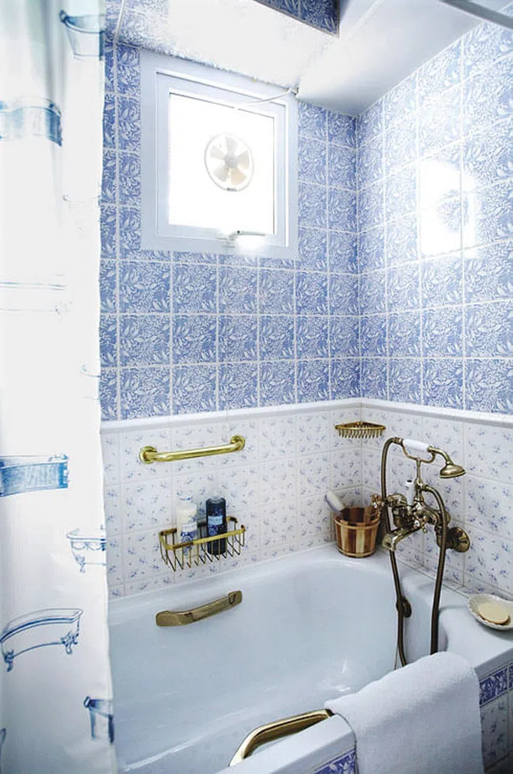White bath tub in an Old English Country style bathroom for this 4-room HDB flat in Sengkang